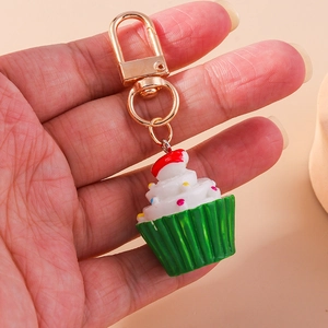 Detailaufnahme eines Cupcake-Schlüsselanhängers mit weißer Creme und goldenem Karabiner