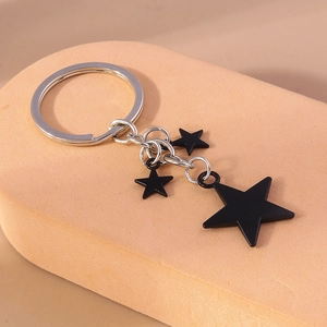 Portachiavi minimalista con stella nera e tre stelle opache su anelli d'argento fini