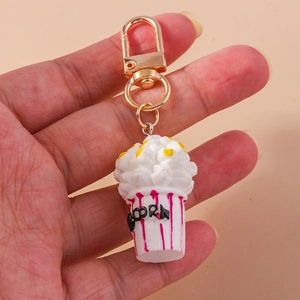 Detailed close-up of a creative popcorn keychain with red and white striped bucket design