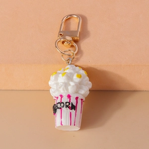 Close-up of cute popcorn keychain with a pink striped bucket and golden lobster clasp