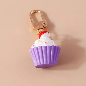 Realistischer Cupcake-Schlüsselanhänger mit roter Kirsche und violetter Form