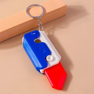 Detail view of mini retractable carrot knife keychain with red, white and blue contrast color