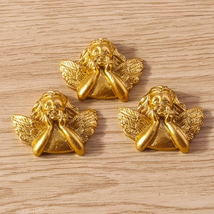 Detailed view of three golden cherub pendants with wings in a hand-on-chin pose