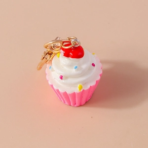 Detailansicht eines rosa Harz-Cupcake-Schlüsselanhängers mit weißer Creme und Goldverschluss