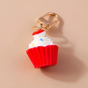 Nahaufnahme vom Cupcake Schlüsselanhänger mit weißer Creme und rotem Herzanhänger