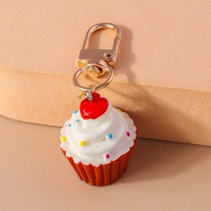 Detail eines Cupcake-Schlüsselanhängers mit weißem Cremewirbel und goldenem Karabiner