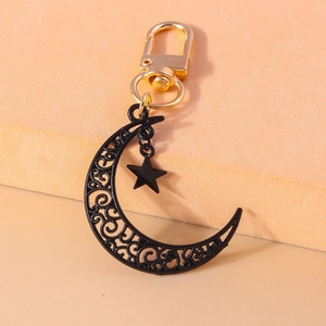 Détail d'un porte-clés bohème lune noire avec pendentif étoile et mousqueton doré chic