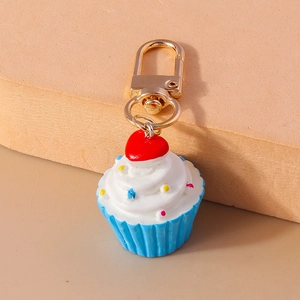 Detailansicht eines Cupcake-Schlüsselanhängers mit weißer Sahne und goldenem Karabinerhaken