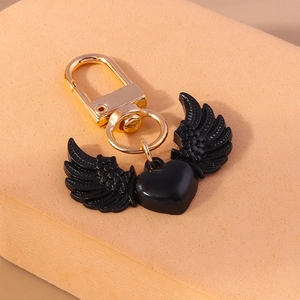 Détail du porte-clés cœur noir de style gothique avec ailes et fermoir doré