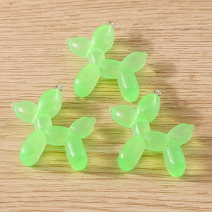 Detailed macro view of three translucent green resin balloon dog pendants with glitter