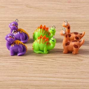 Close-up of cute colorful resin dinosaur charms with metal hooks for DIY jewelry making