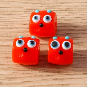 Three cute orange resin monster beads with blue horns for DIY jewelry making