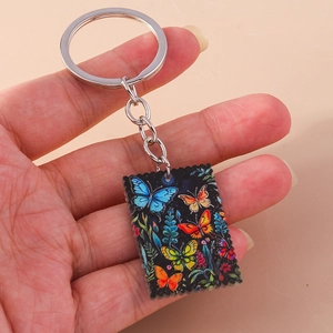 Detail showing the colorful butterfly oil painting pattern on a square keychain pendant