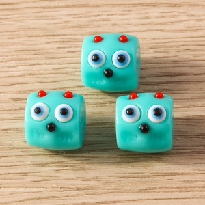 Macro shot of blue monster resin beads for DIY jewelry making on a wood background