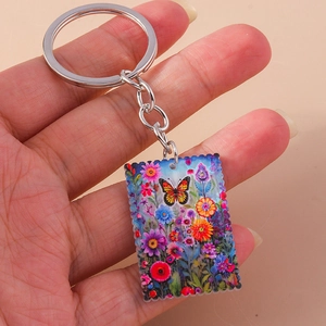 Close-up of a rectangular acrylic keychain featuring colorful butterfly and floral patterns