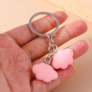 Close-up of pink cloud-shaped resin keychain with smooth matte finish and metal ring