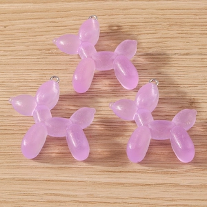 Detailed macro view of purple translucent resin balloon dog charms with glitter finish