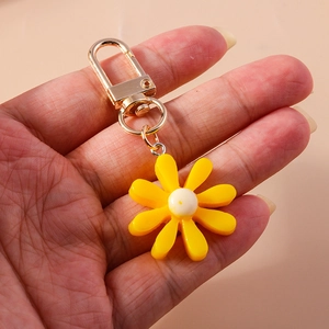 Nahaufnahme von gelbem Sonnenblumen-Schlüsselanhänger aus Harz mit goldenem Verschluss