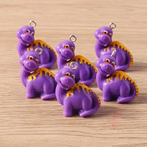 Group of cute purple cartoon dinosaur charms with yellow spikes and silver metal ring hooks