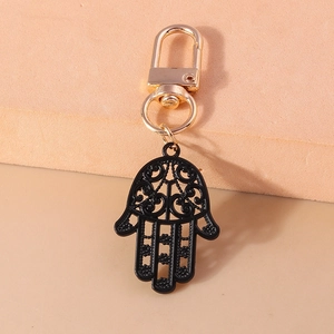Détail d'un porte-clés Main de Fatma en métal noir avec fermoir mousqueton doré et gravures