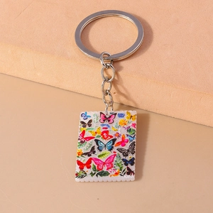 Macro shot of stamp-edged butterfly acrylic pendant with polished silver hardware chain