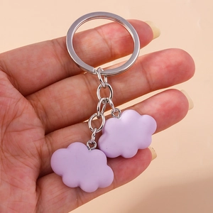 Detail of lavender double cloud resin keychain with silver ring held by hand