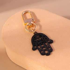 Détail du porte-clés Main de Fatma avec pendentif noir filigrané et clip doré