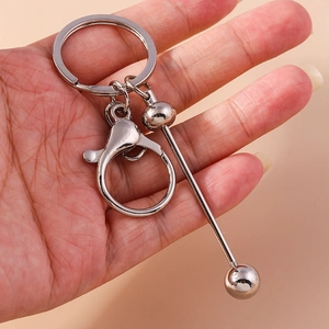 Silver geometric metal keychain with barbell pendant and lobster clasp held in hand
