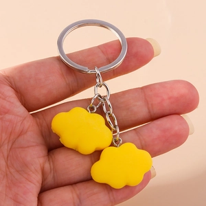 Detailed close-up of a vibrant yellow cloud keychain featuring a soft resin finish