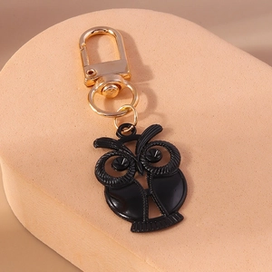 Vue détaillée d'un porte-clés hibou avec émail noir et accents métalliques dorés