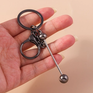 Industrial style gunmetal alloy keychain with barbell pendant held in hand for daily use
