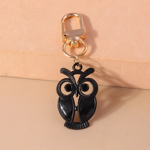 Détail d'un porte-clés chouette noire avec textures fines et fermoir doré mousqueton