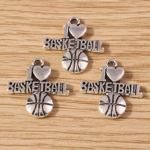 Macro detail of antique silver basketball charms with heart and letter engravings