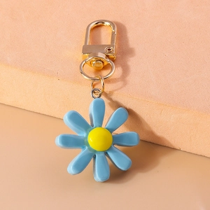 Detailansicht eines blauen Harz-Gänseblümchen-Schlüsselanhängers mit Goldhaken