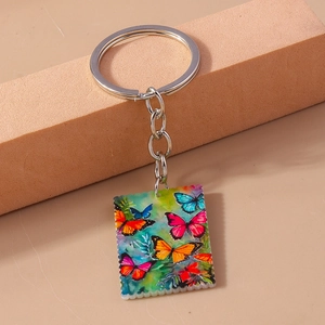 Detail of a rectangular keychain pendant featuring vibrant colorful butterfly oil painting art