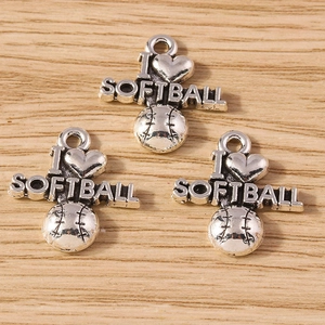 Macro detail of antique silver I Love Softball heart pendants on a wood surface
