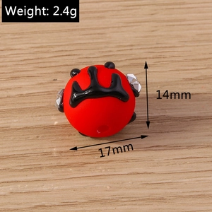 Nahaufnahme einer 17mm roten Perle mit schwarzem Kronenmuster und glänzenden Strasssteinen