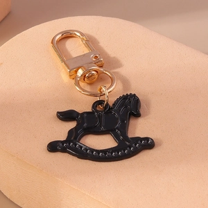 Vue détaillée d'un porte-clés cheval à bascule noir avec fermoir et anneau dorés