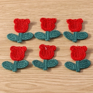 Detailed close-up of six handmade knitted tulip flower pendants for DIY craft projects