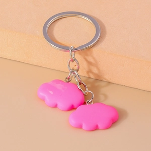 Detail view of pink resin cloud charms on a silver metal keychain with a soft matte finish