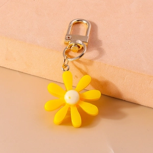 Nahaufnahme von gelbem Gänseblümchen-Schlüsselanhänger aus Harz mit goldenem Karabinerhaken