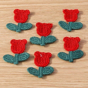Detail view of handmade crochet Christmas flower appliques on a light wood background