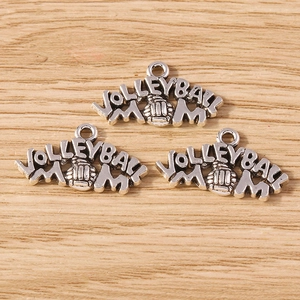 Detailed macro of vintage silver volleyball mom charms on a rustic wooden surface