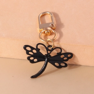 Vue détaillée d'un porte-clés libellule noire avec ailes dorées et fermoir en métal