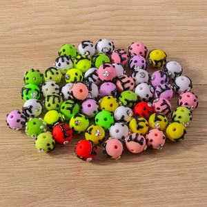 Buntes Set aus DIY-Diamantperlen mit schwarzer Emaille auf hellem Holzgrundhintergrund