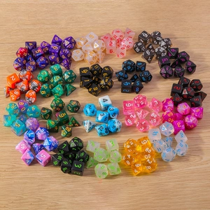 Close-up of assorted polyhedral dice sets with clear numbers on light wood background