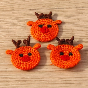 Close-up of handmade crochet reindeer patches with detailed orange knit texture