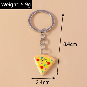 Detailed view of pizza keychain with cute cartoon face on a beige background
