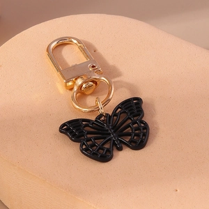 Vue détaillée d'un porte-clés papillon noir avec fermoir mousqueton doré élégant