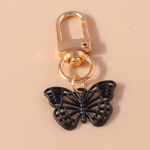 Détail d'un porte-clés papillon noir évidé avec fermoir mousqueton doré et anneau
